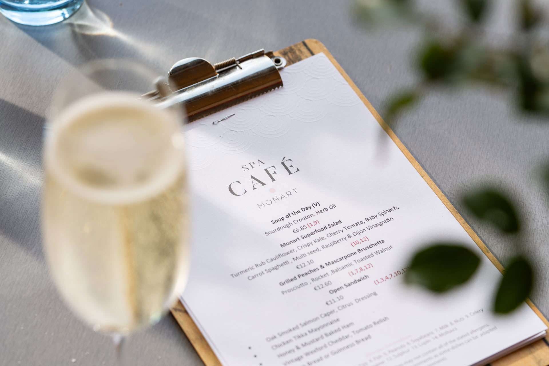 photo of menu for monart spa cafe with a glass of prosecco